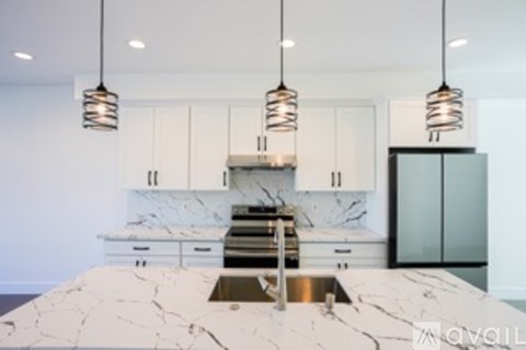 A kitchen with a marble countertop and a sink.