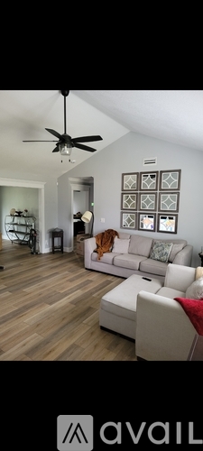 A living room with a white couch and a ceiling fan.