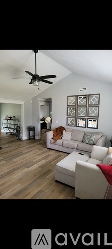 A living room with a white couch and a ceiling fan.