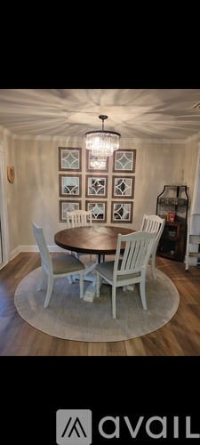 A dining room with a round table and chairs.