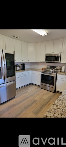 A kitchen with white cabinets and stainless steel appliances.