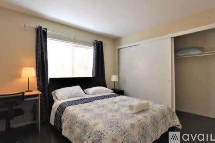 A bedroom with a bed, desk, and chair.