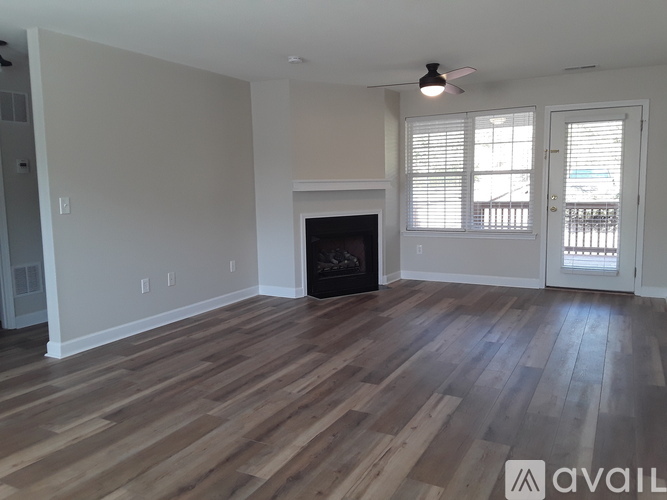 A living room with a fireplace and wood flooring.