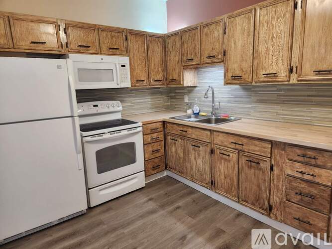 A kitchen with wooden cabinets and a white refrigerator.