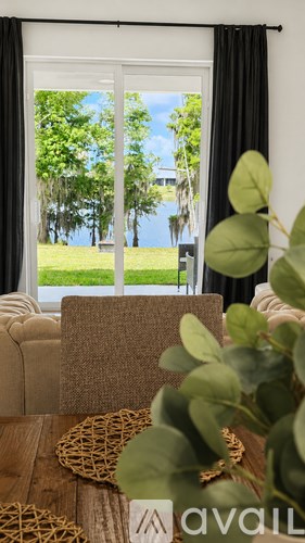 A living room with a couch and a window showing a view of trees and a building.
