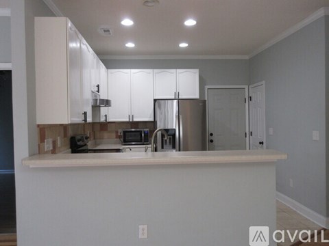 A kitchen with white cabinets and a white countertop.