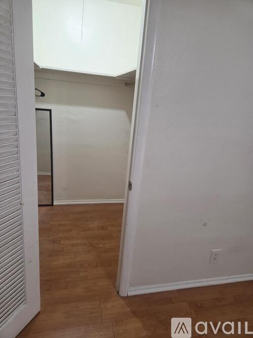 A room with wooden flooring and white walls.