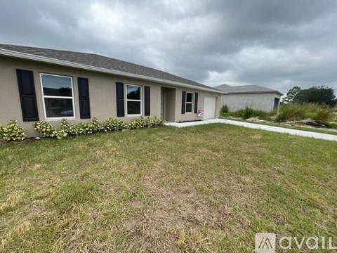 A house with a grey roof and black shutters is for sale.