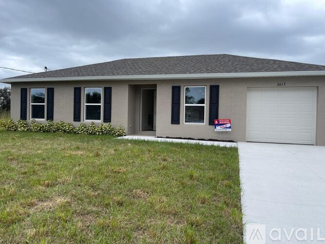A house with a garage door and a sign that says "For Sale".