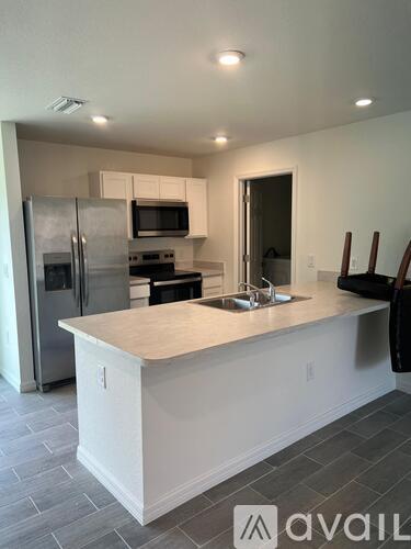A kitchen with a white island and stainless steel appliances.