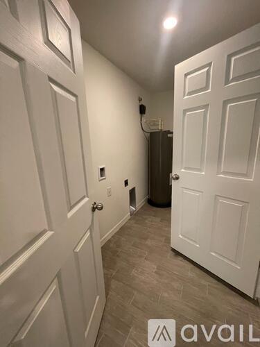 A hallway with white doors and a tiled floor.