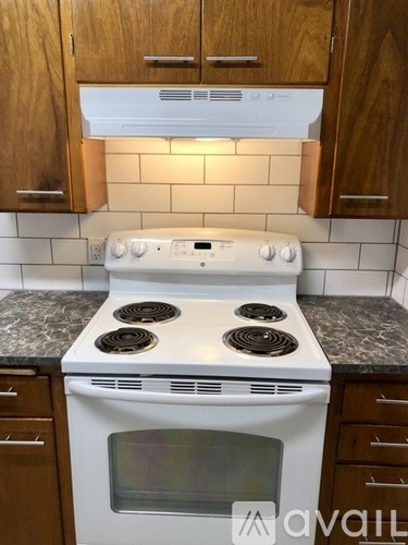 A white stove top oven with four burners and a microwave oven below it.