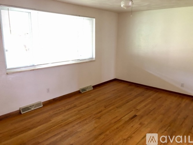 A room with wooden flooring and a window.