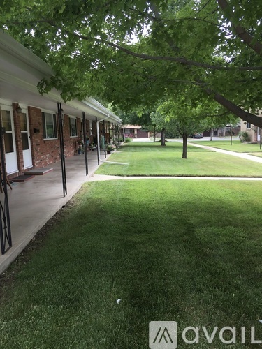 A grassy area in front of a building with a tree.