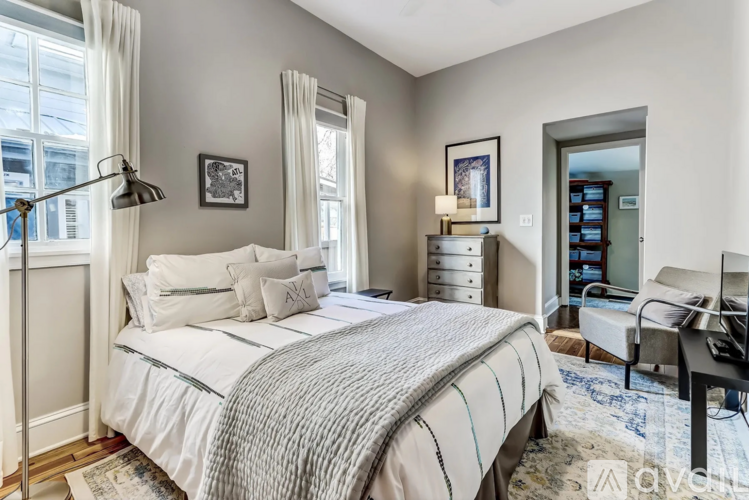 A bedroom with a large bed and a desk with a chair.