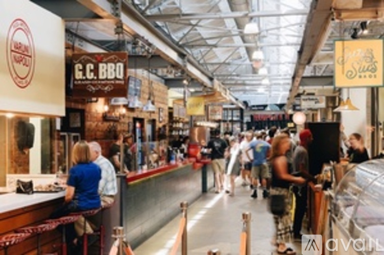 A busy indoor food court with people dining and a sign that says G.C. BBQ.