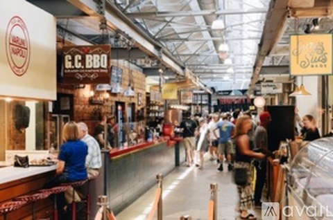 A busy indoor food court with people dining and a sign that says G.C. BBQ.
