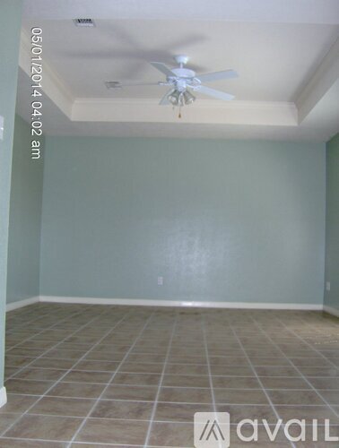 A room with a ceiling fan and tile flooring.