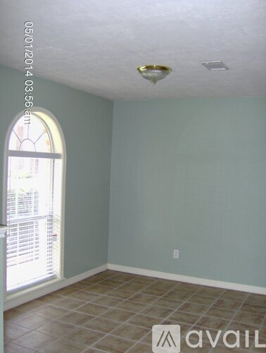 A room with a window and a tiled floor.