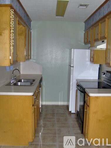 A kitchen with wooden cabinets and a white refrigerator.