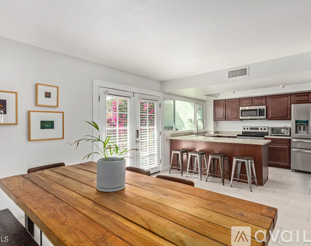 A wooden table with a potted plant on it in a kitchen.