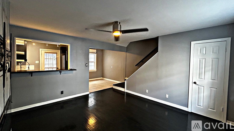 A spacious room with a staircase leading to the second floor.