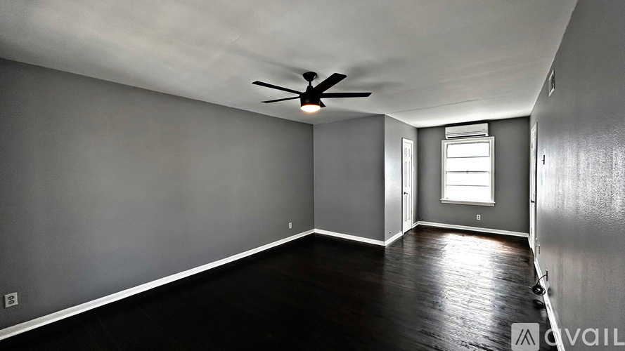 A room with a ceiling fan and a window.