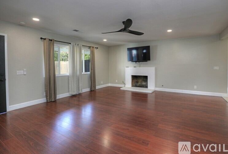 A living room with a fireplace and a television.