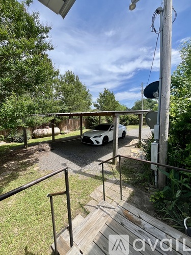 A white car is parked in a driveway.