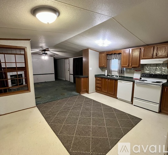 A kitchen with brown cabinets and a white stove top oven.