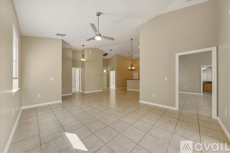 A spacious room with a fan and tiled flooring.