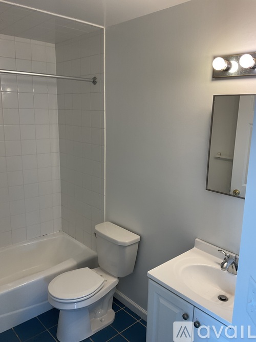 A white toilet sits next to a white sink in a bathroom.