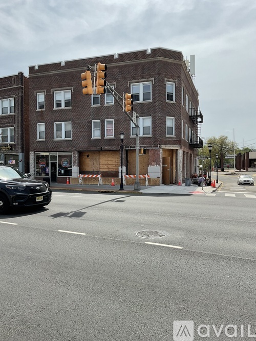 A street view with a car, a traffic light and a building.
