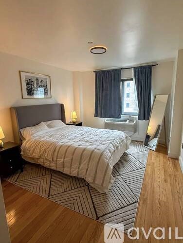 A bedroom with a large bed and a framed picture on the wall.