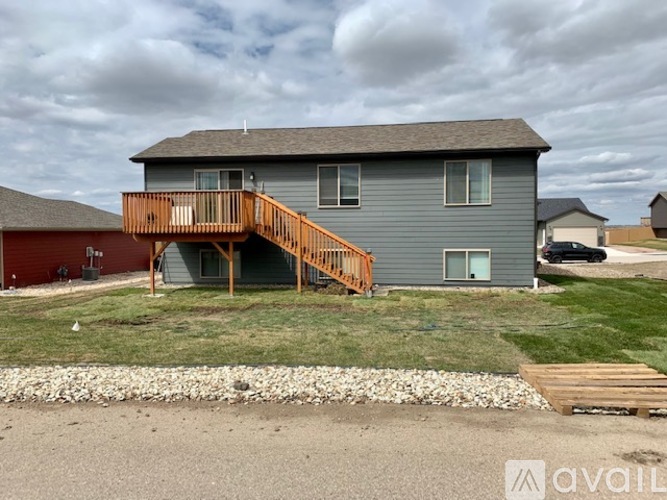 A house with a grey exterior and a wooden deck.