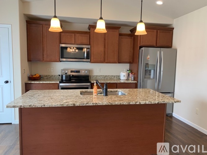 A kitchen with brown cabinets and granite countertops.