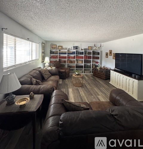 A living room with brown leather furniture and a flat screen TV.