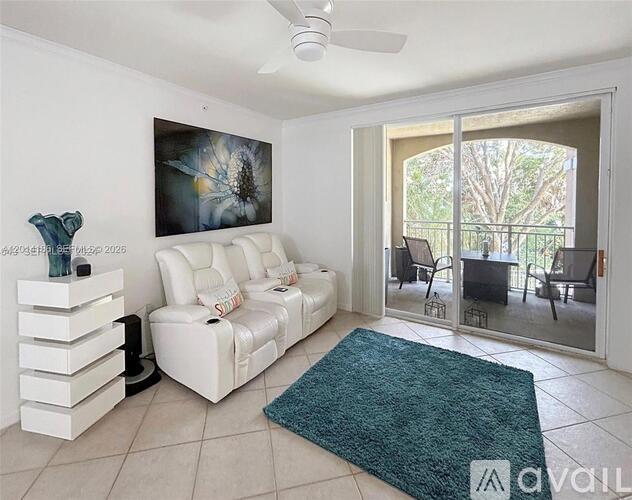 A living room with a white couch and a painting of a flower on the wall.