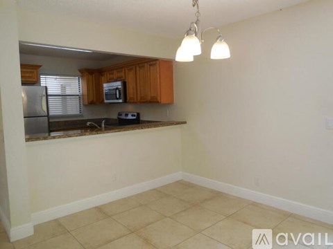 A kitchen with wooden cabinets and a stainless steel refrigerator.