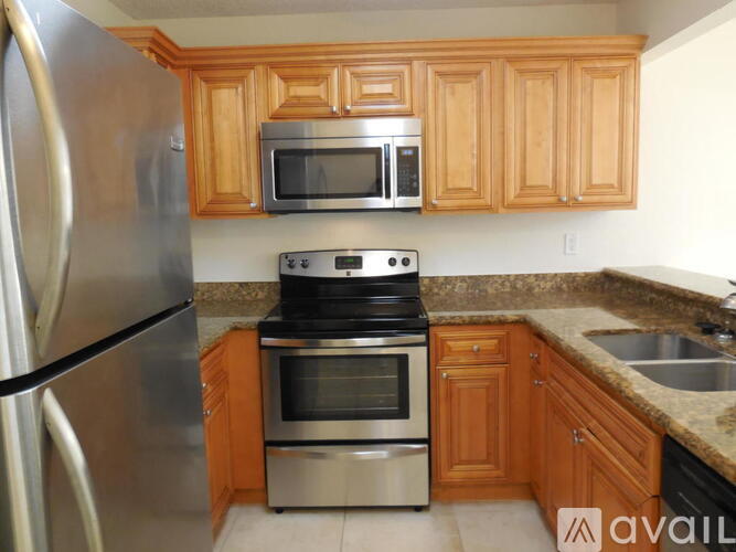 A kitchen with wooden cabinets and stainless steel appliances.