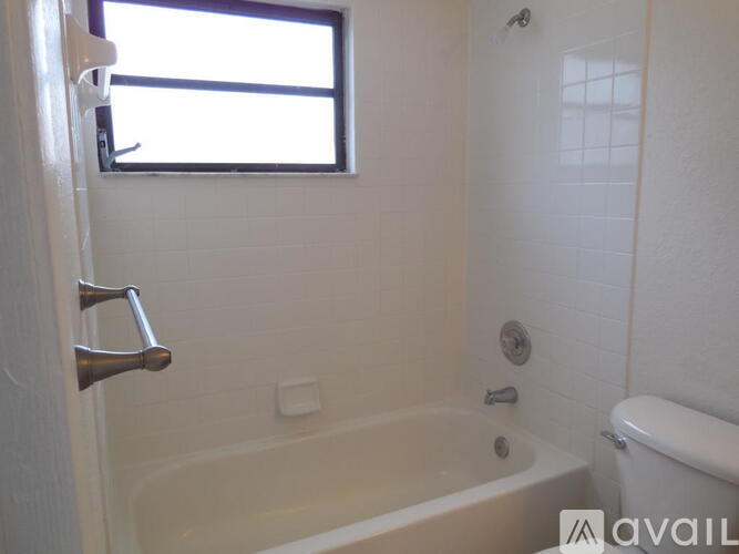 A white bathroom with a tub, toilet, and sink.