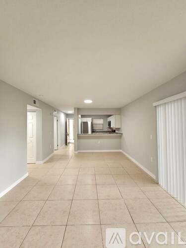 A spacious room with tiled flooring and white walls.