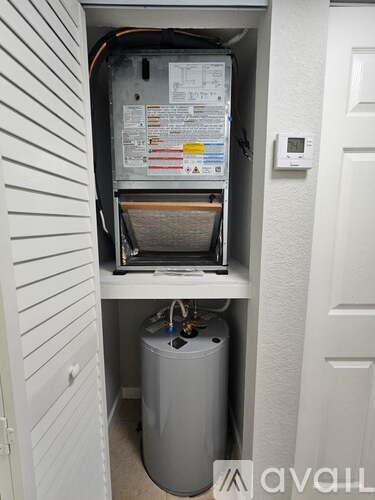 A tankless water heater installed in a wall next to a door.