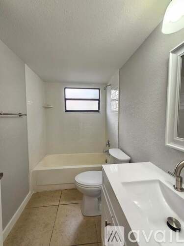 A small bathroom with a toilet, sink, and bathtub.