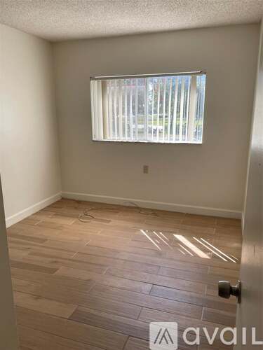 A room with a window and wooden flooring.
