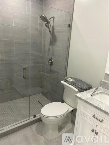A white toilet in a bathroom with a glass shower stall.