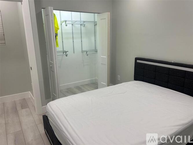 A bedroom with a white bed and a walk-in closet.