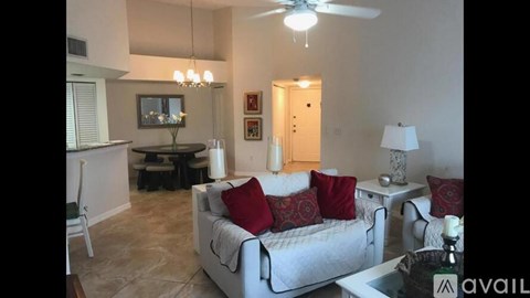 A living room with a white couch and a chandelier.