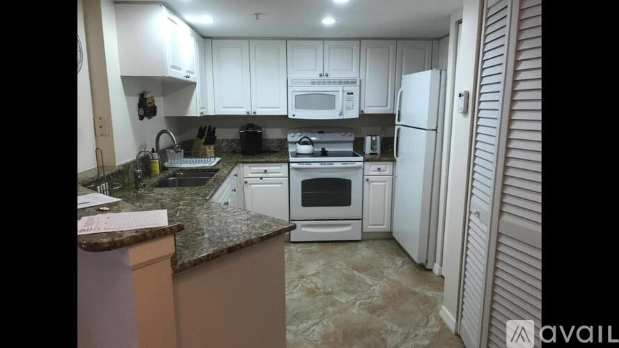 A kitchen with white cabinets and appliances.