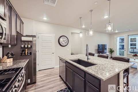 A modern kitchen with dark wood cabinets and granite countertops.
